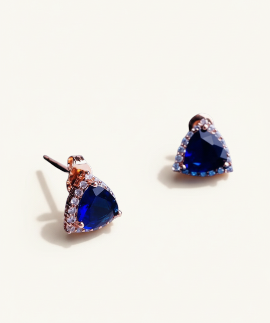 Luxiage gold-tone triangle earrings with deep blue crystals and clear accent stones. Modern geometric design.