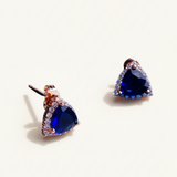 Luxiage gold-tone triangle earrings with deep blue crystals and clear accent stones. Modern geometric design.